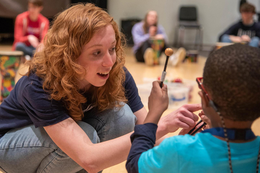 A person teaches a young student.