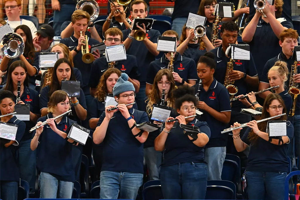 Duquesne University Pep Band performs. Students hold flutes, trumpets, and other instruments.