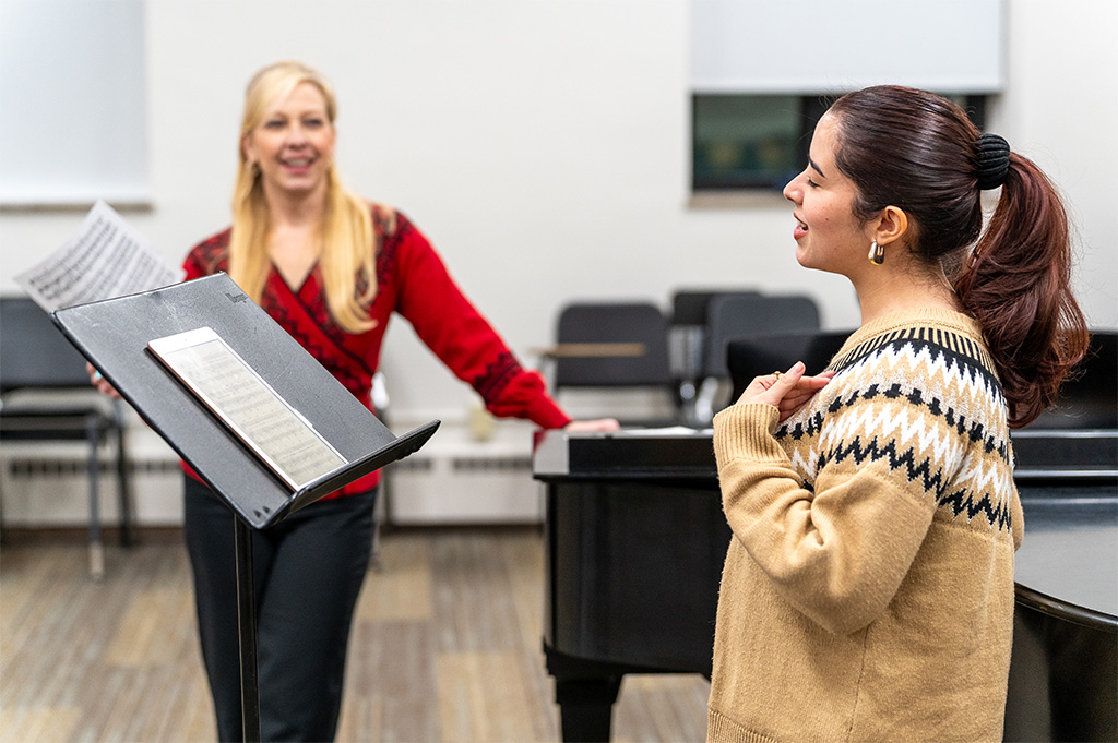 A singer and her teacher working together.