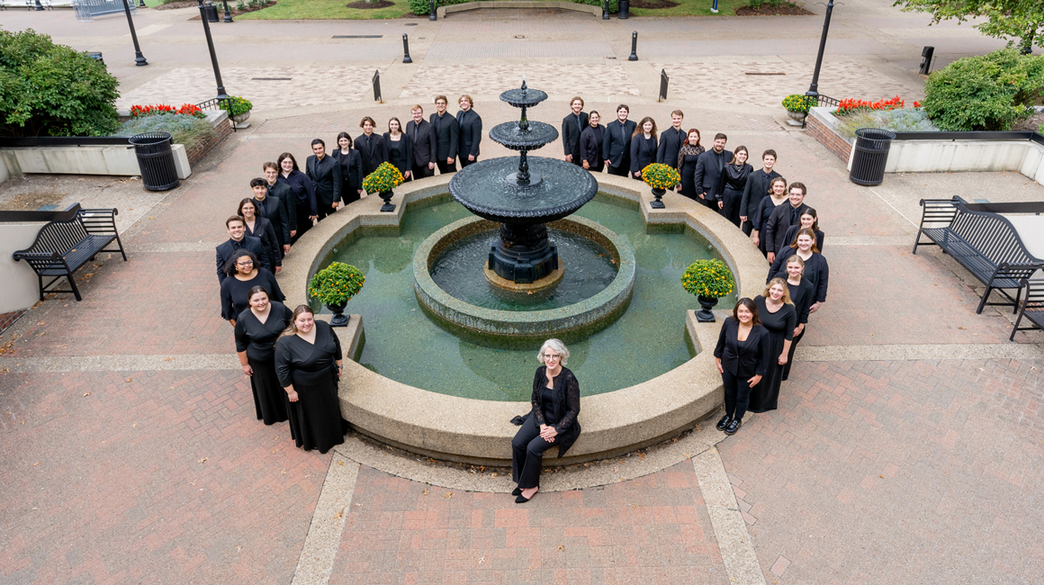 Voices of Spirit poses for a group photo around a fountain..