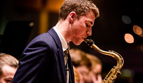 A person plays a saxophone.