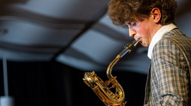 A student plays a saxophone.