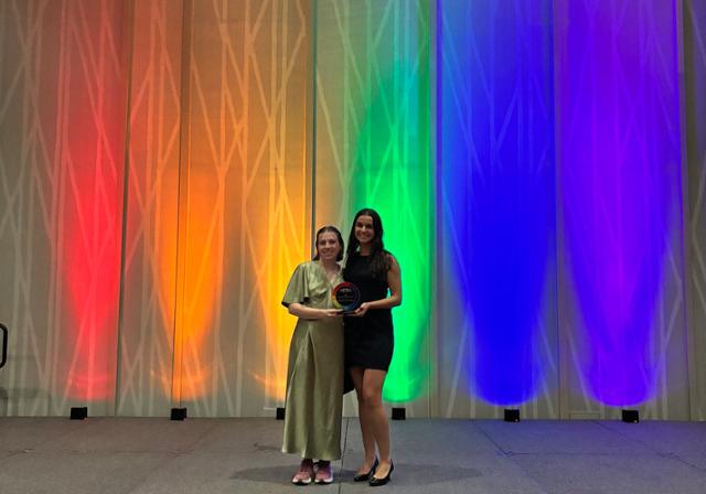 tow people holding up an award