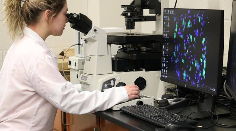 student looking into a microscope