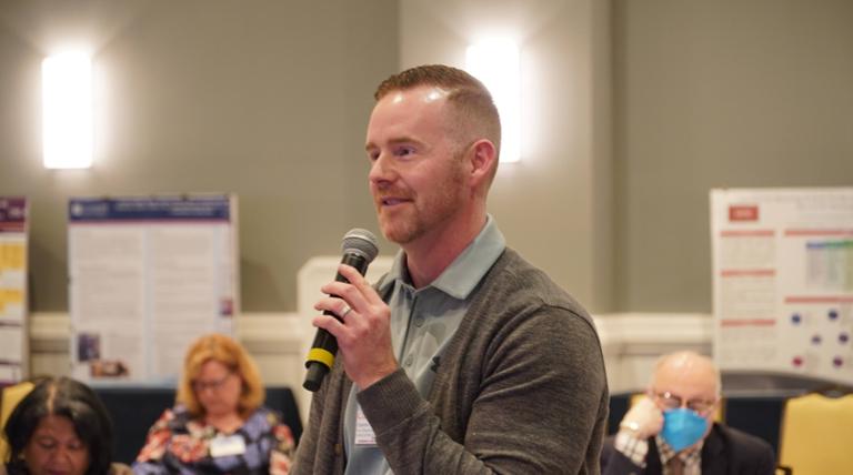 attendee speaking into a microphone during q and a session