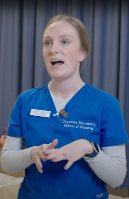 female nurse wearing blue scrubs in lab room