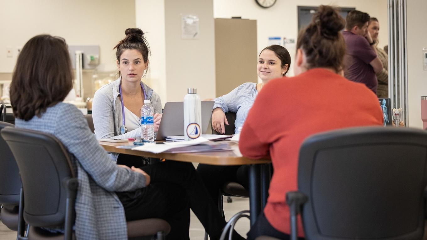 A group of nurses sit in discussion.