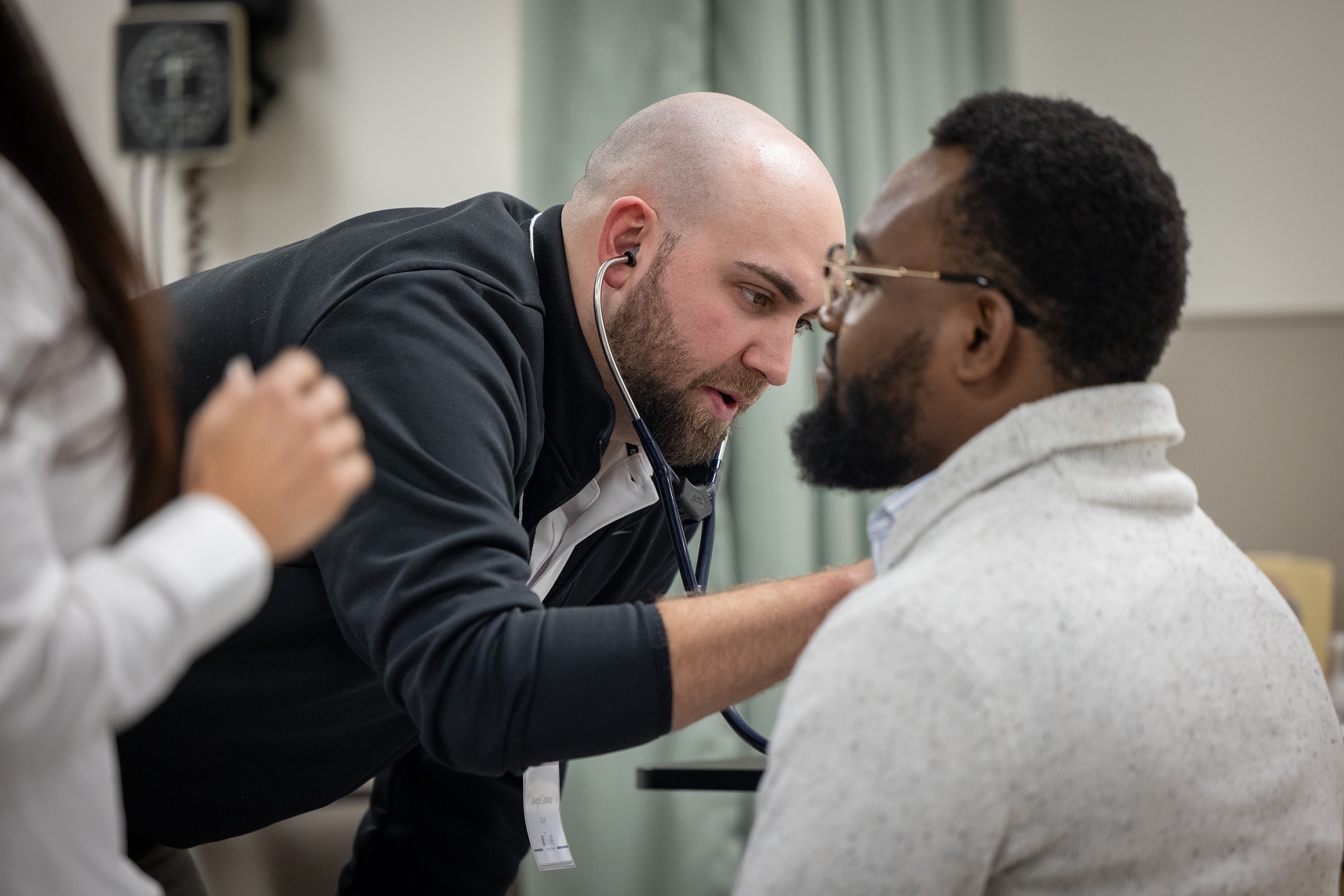 A graduate nursing student works with a volunteer during a demonstration. 