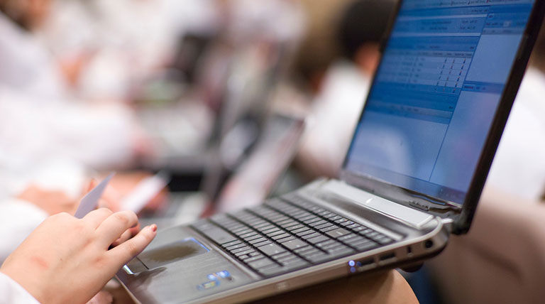 a hand clicking on a laptop trackpad