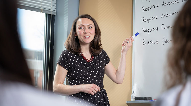 woman presenting in front of white board