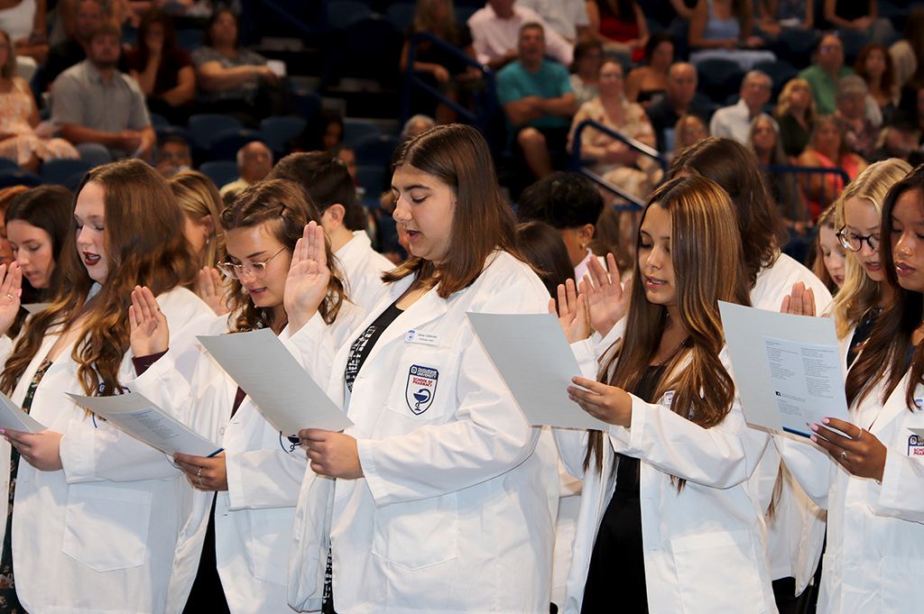 students reciting oath of professionalism at white coat ceremony