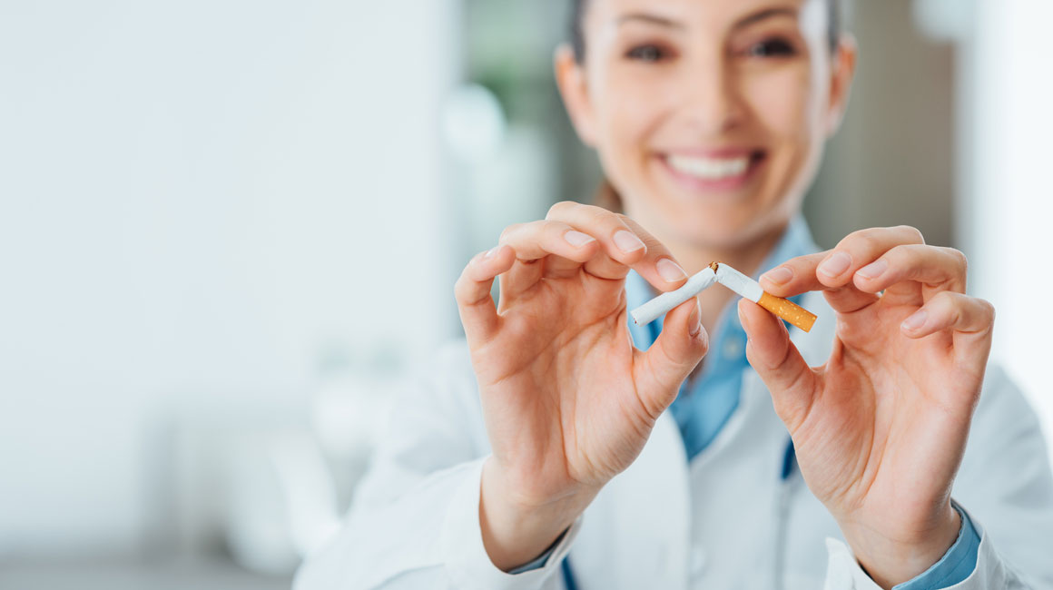 smiling woman breaking cigarette in half