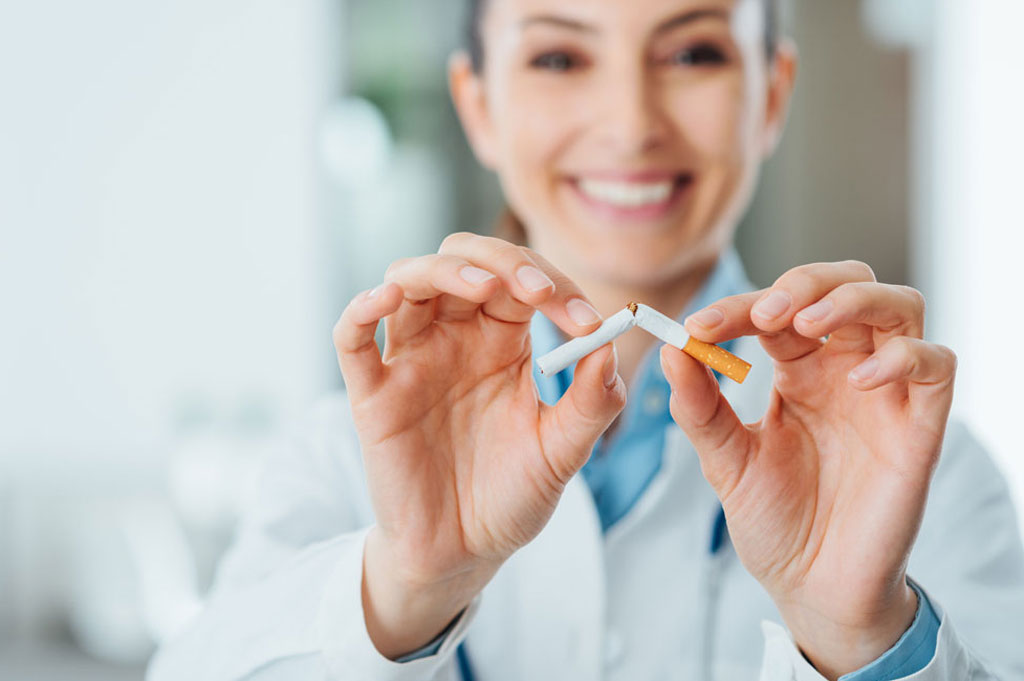 smiling woman snapping a cigarette in half