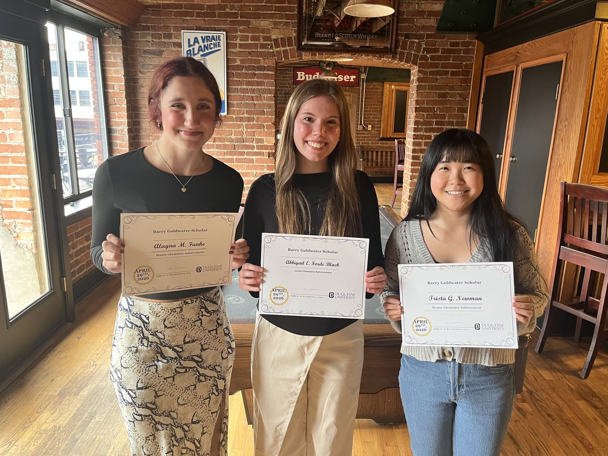 three girls holding up awards