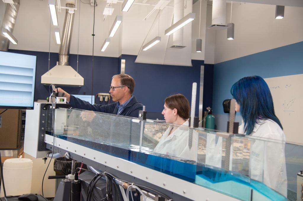 three people at a water table