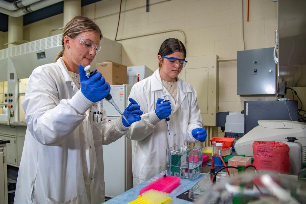 two girls holding beakers