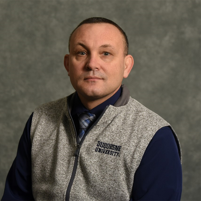 a man in a grey vest