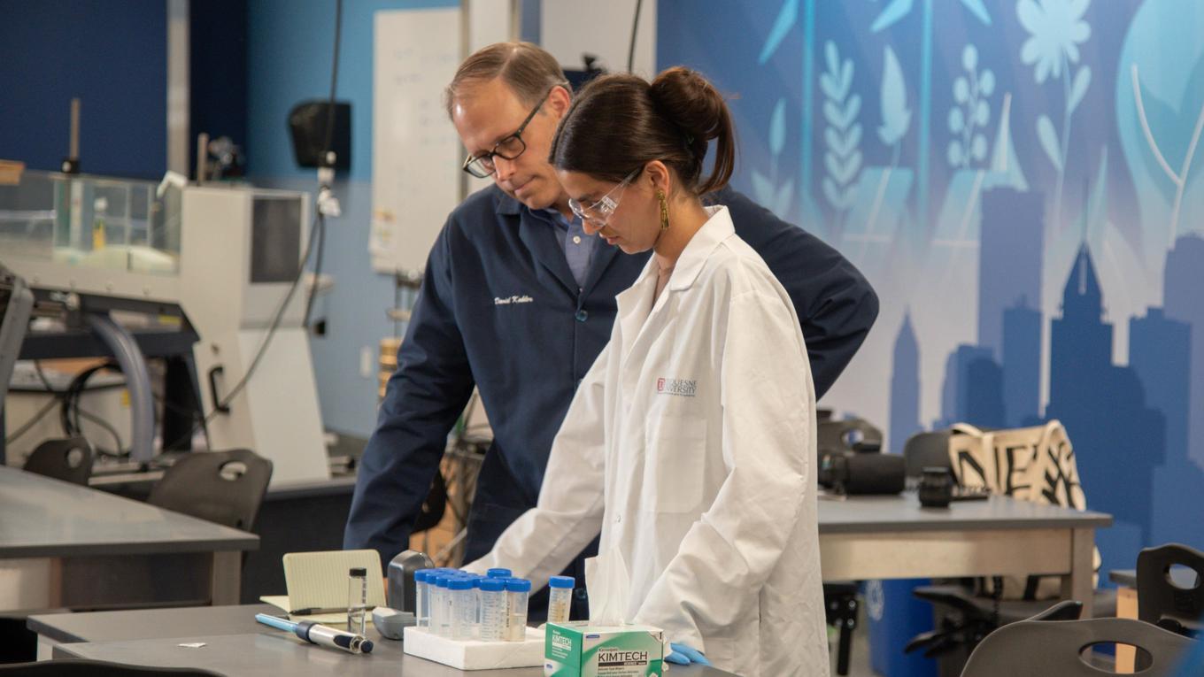 A student and professor are working in a lab.