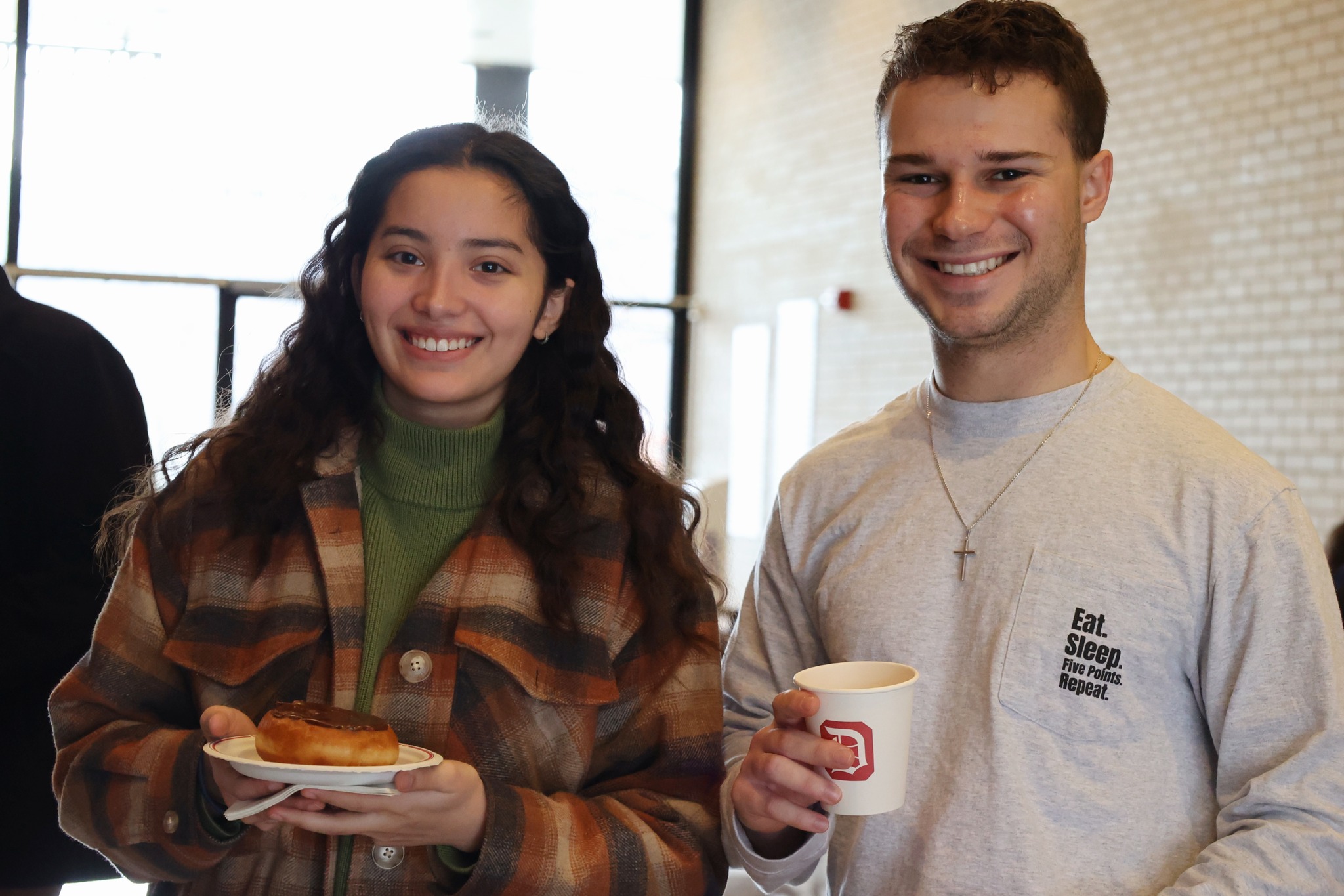 a boy and girl with a donut and cup