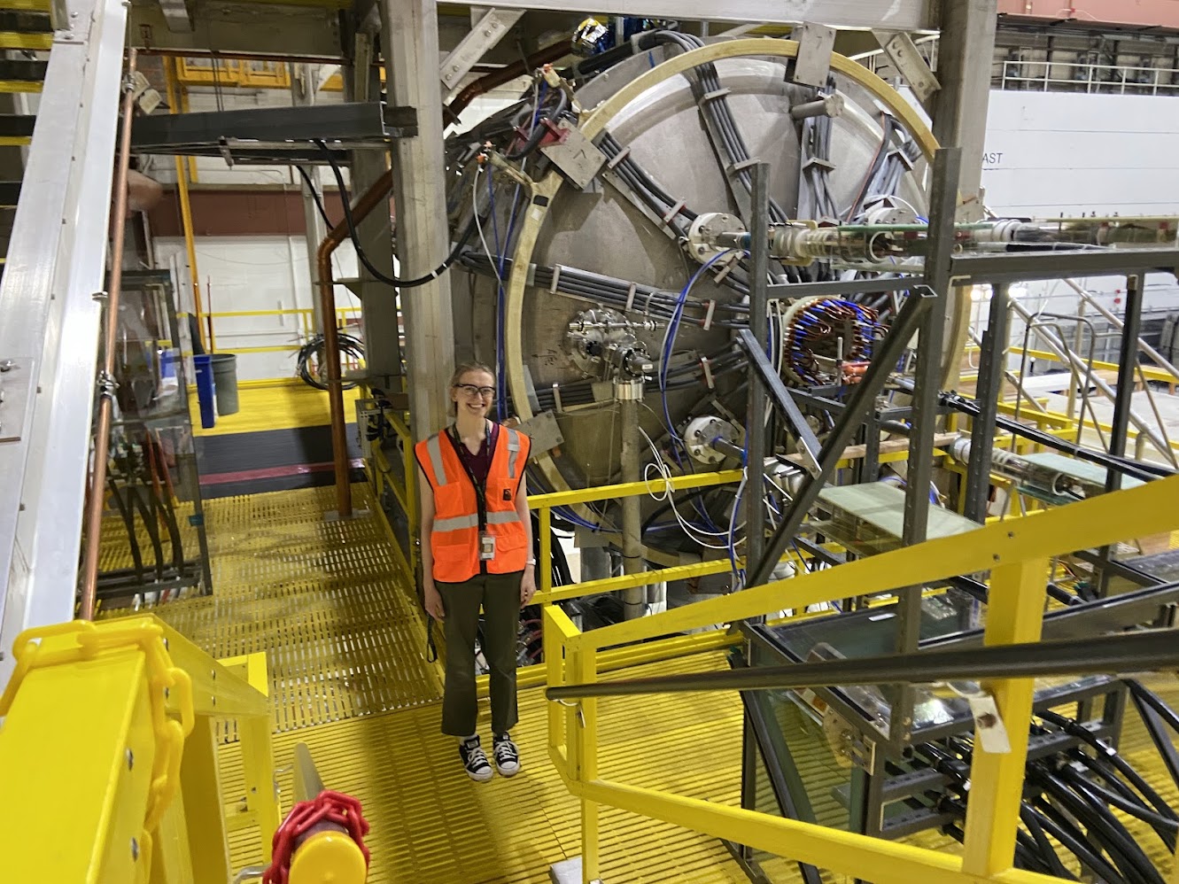 a girl on a piece of equipment wearing goggles and an orange jacket