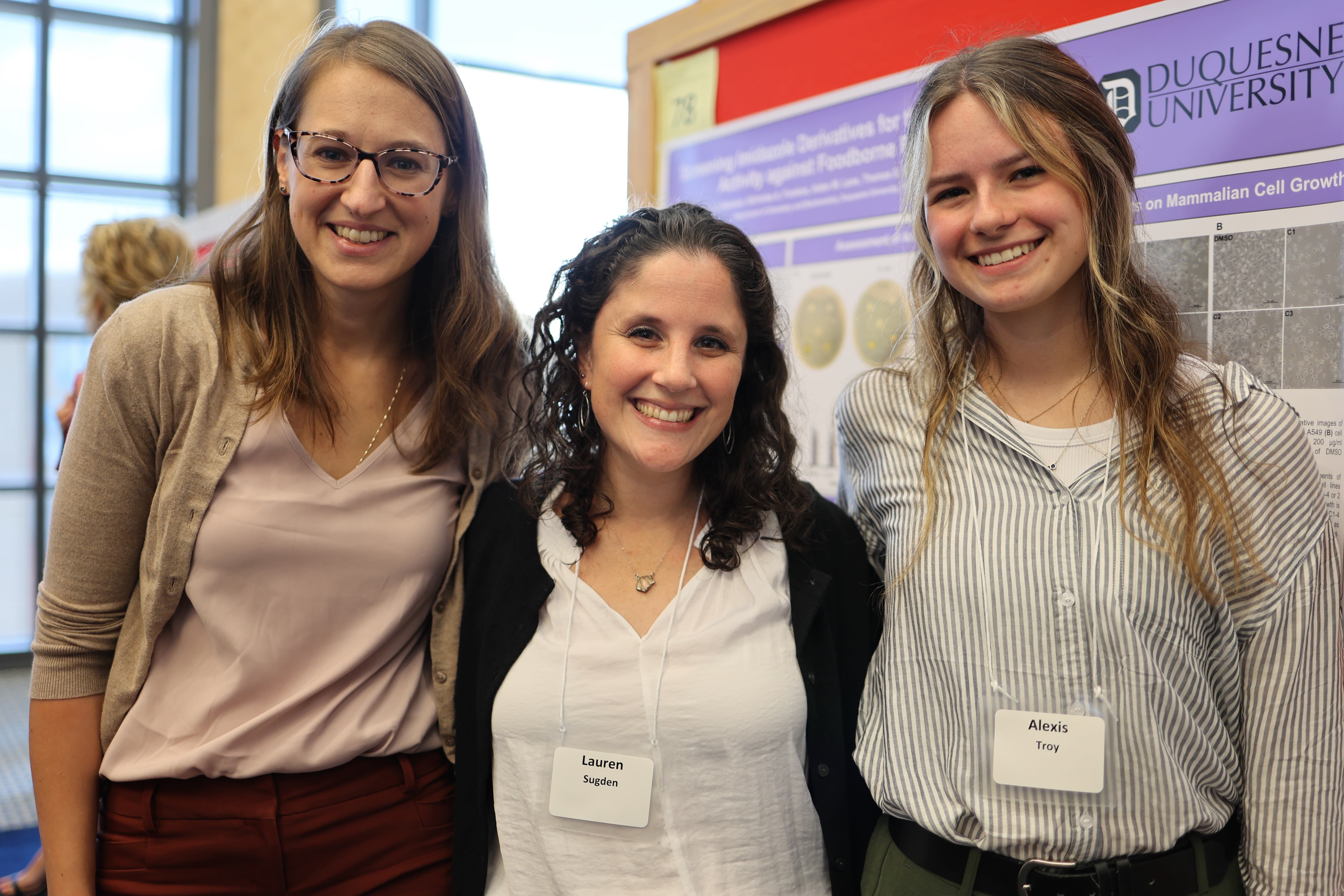 three girls in front of a poster