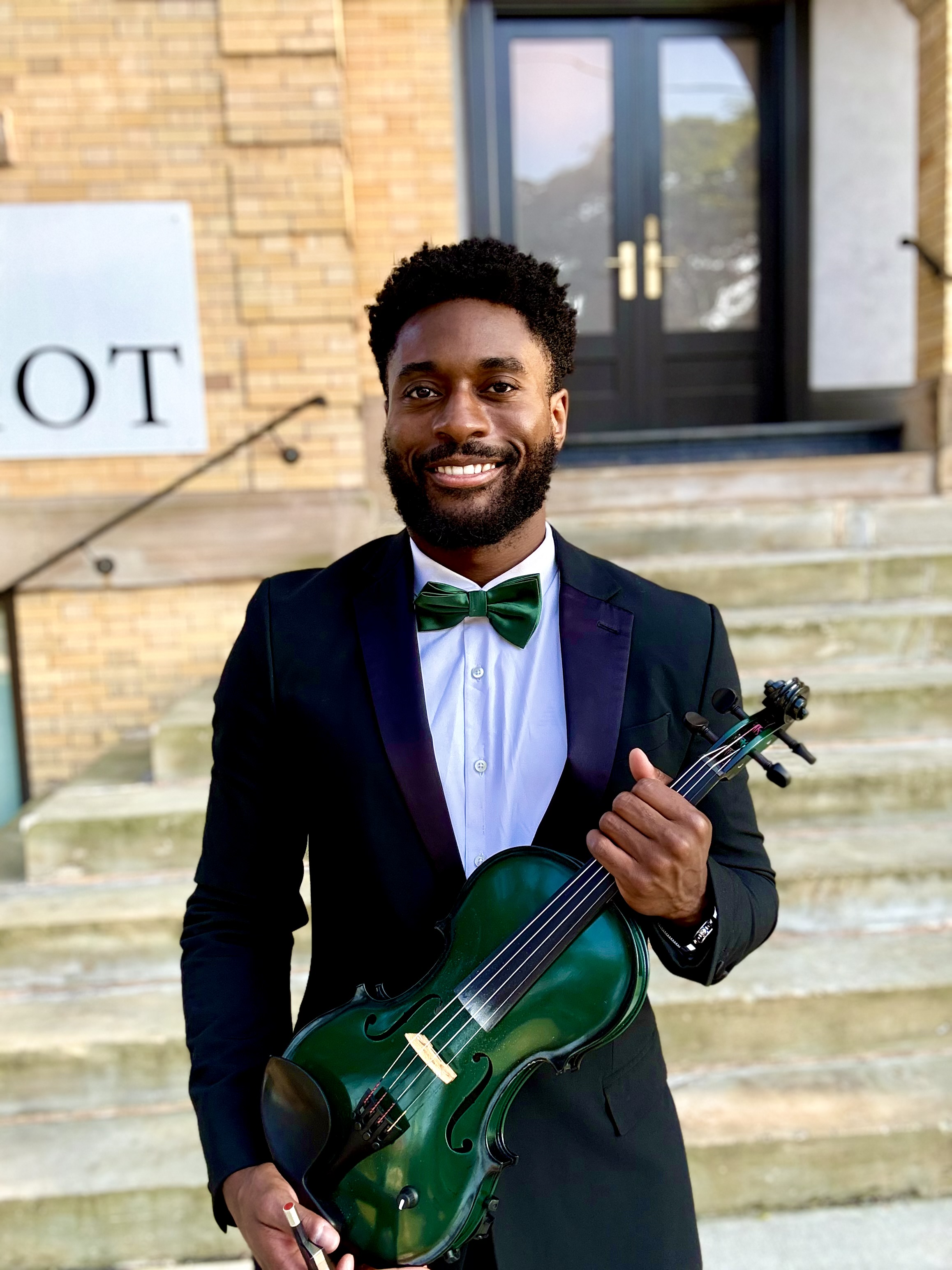 a male holding a violin