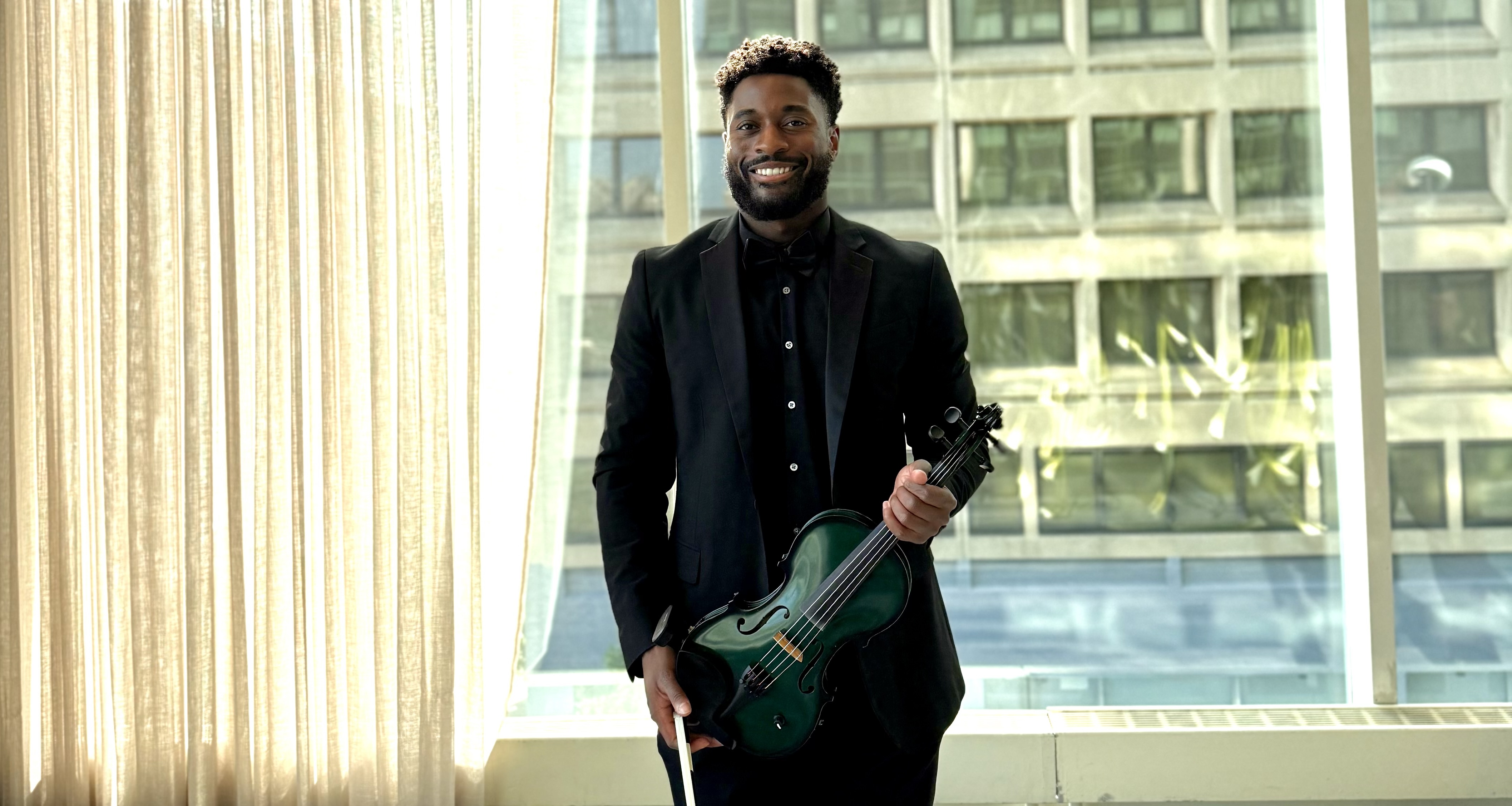 a male holding the violin