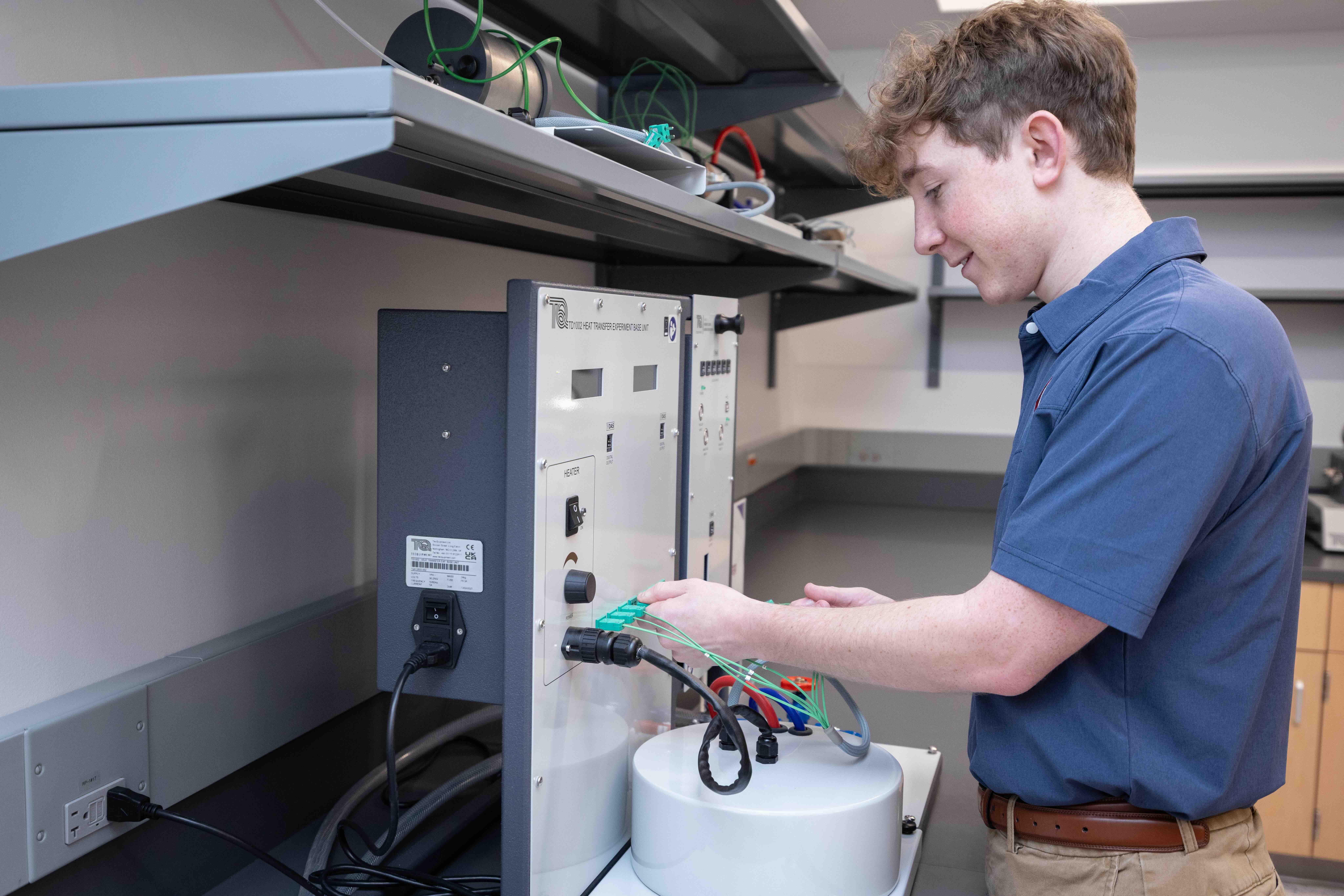 a male in a blue shirt holding a piece of equipment