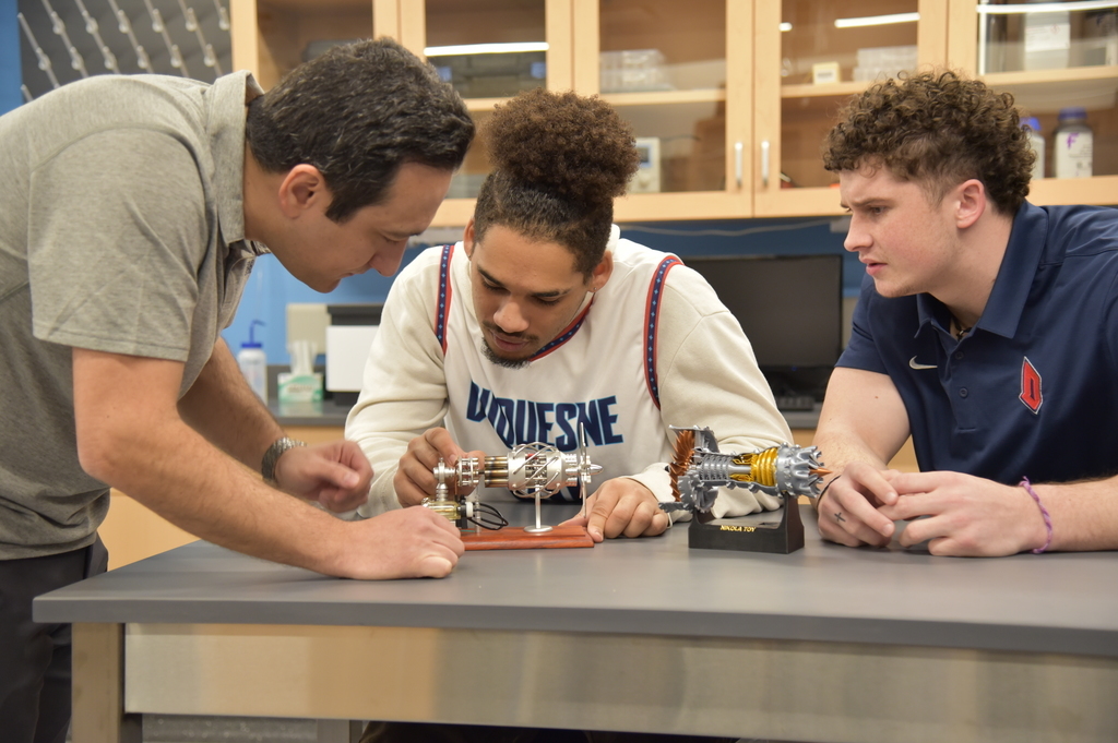 people looking at mechanical engineering equipment