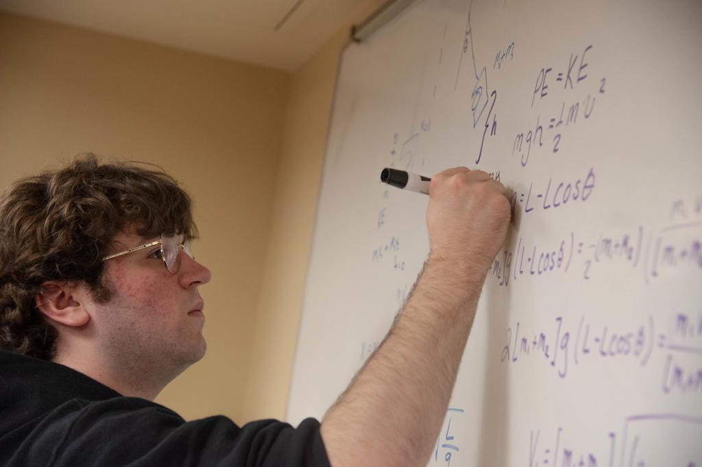 a male writing on a board
