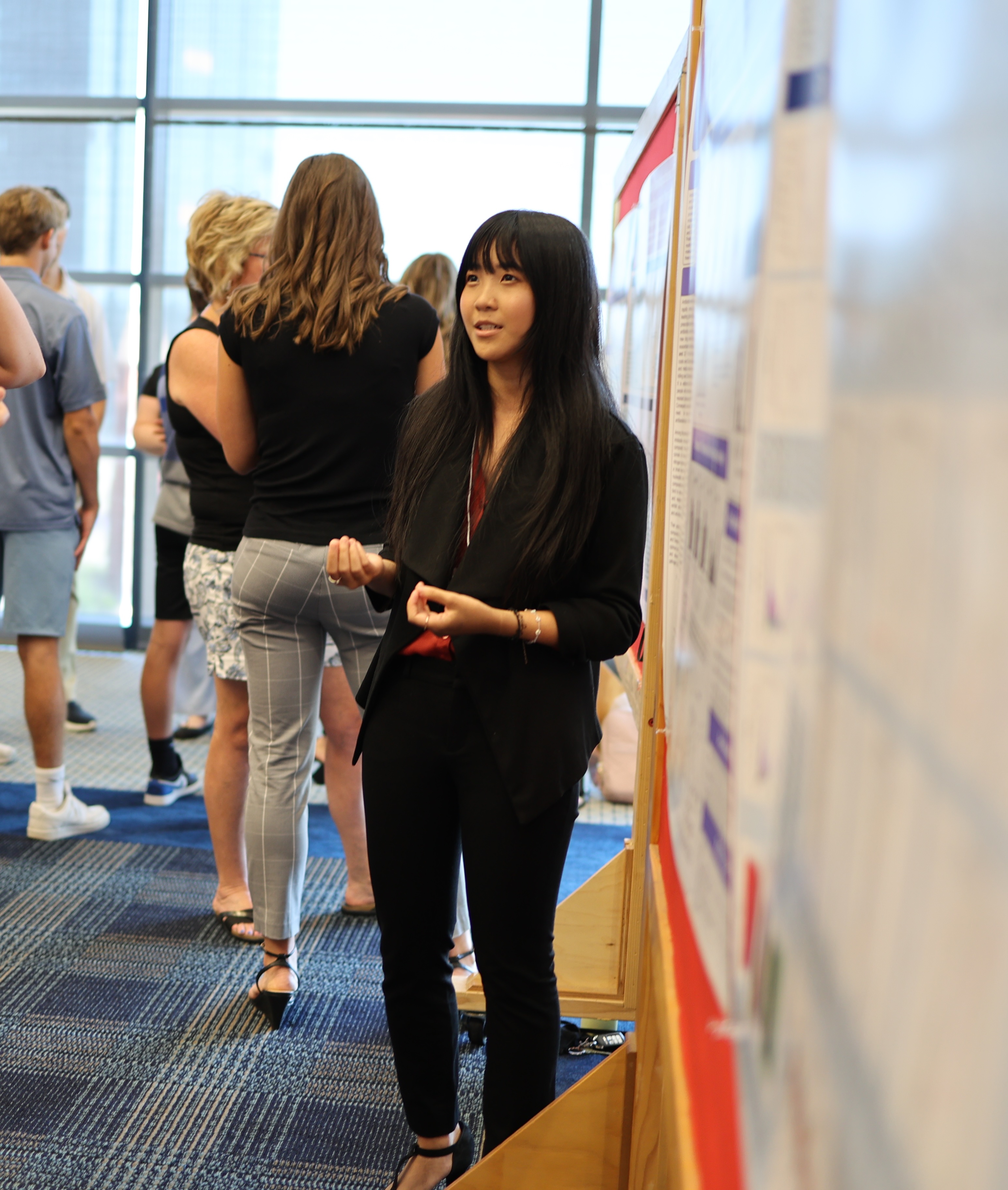 a girl standing in front of a poster