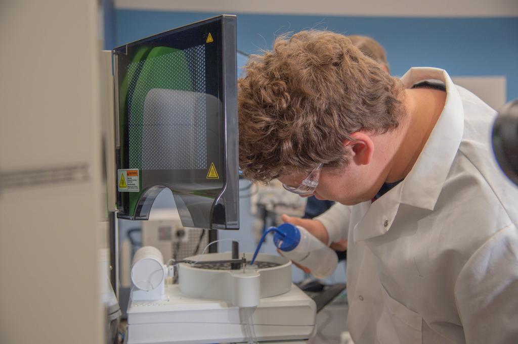 a boy holding a beaker