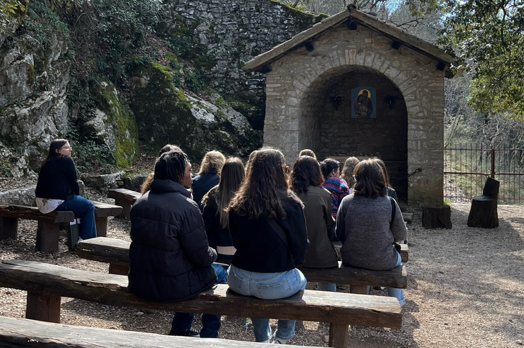 Students in front of an outdoor alter, reflecting and praying.