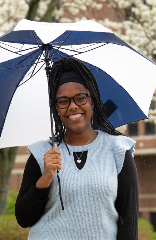 Samiya Henry standing outside on campus with umbrella