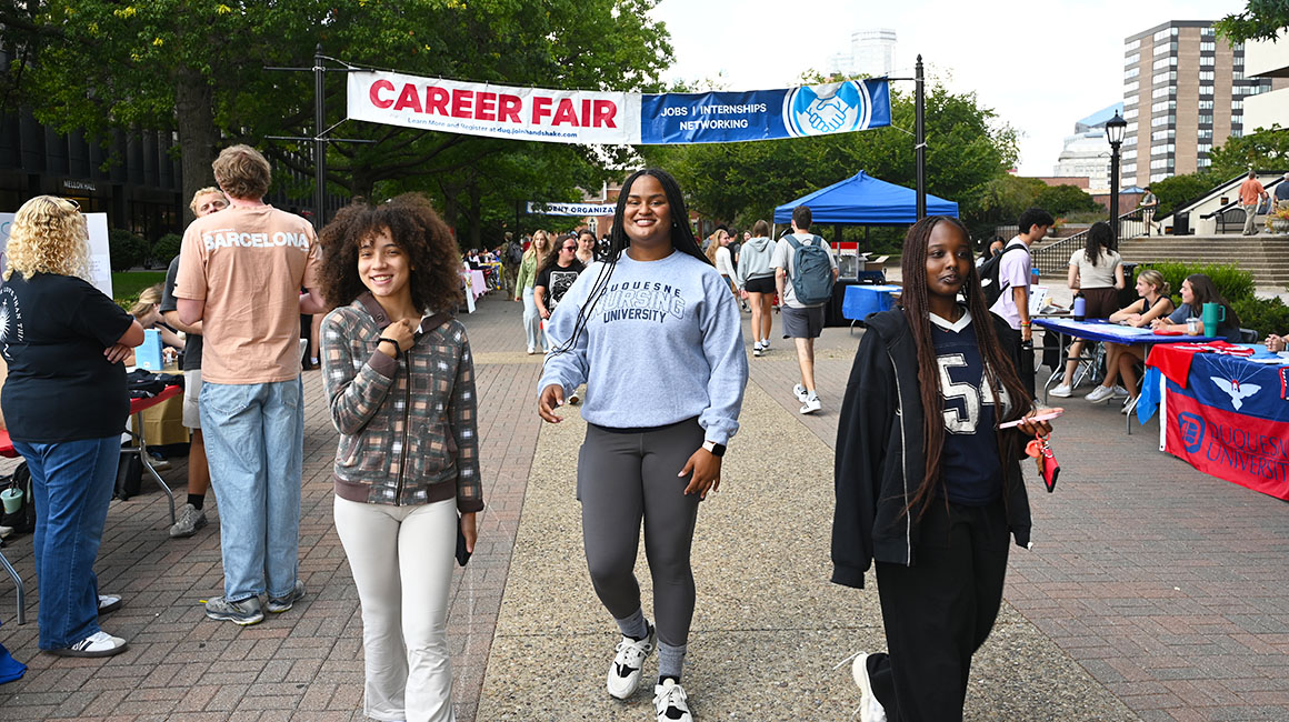 Three students walking on A-Walk during the 2025 Student Expo