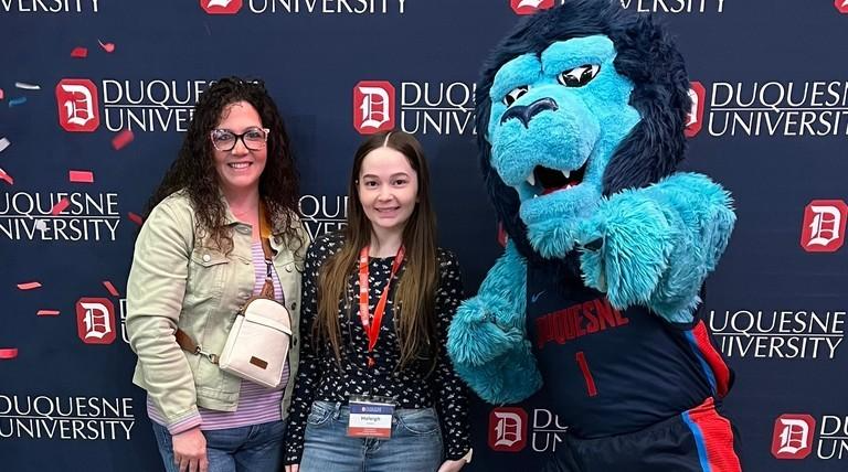 Admitted students celebrating at an admitted student event with signs that read FUTURE DUQUESNE DUKE