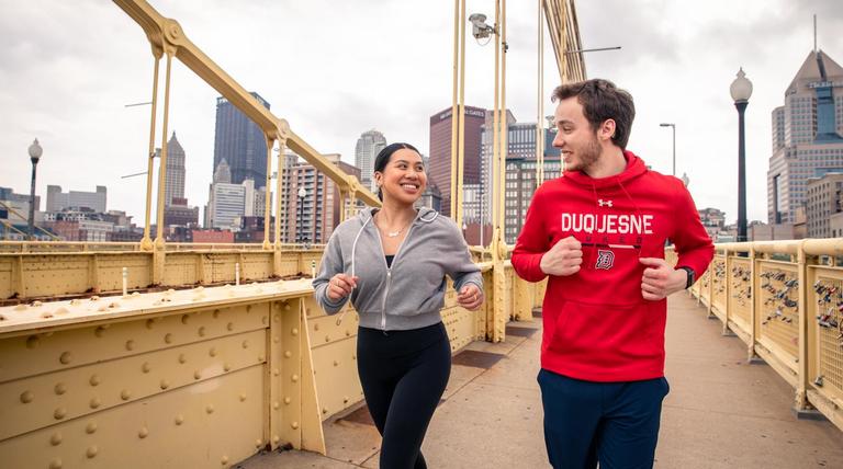 Duquesne students running on the Roberto Clemente bridge in downtown Pittsburgh