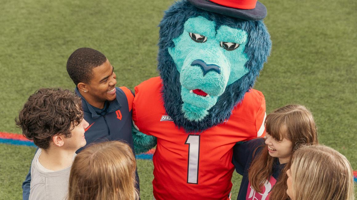 Duquesne students with mascot on Rooney field