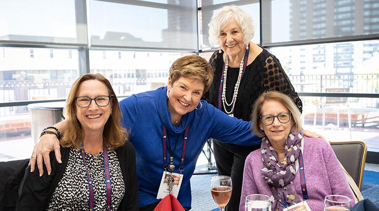 Four alumni pose at Golden Dukes Reunion