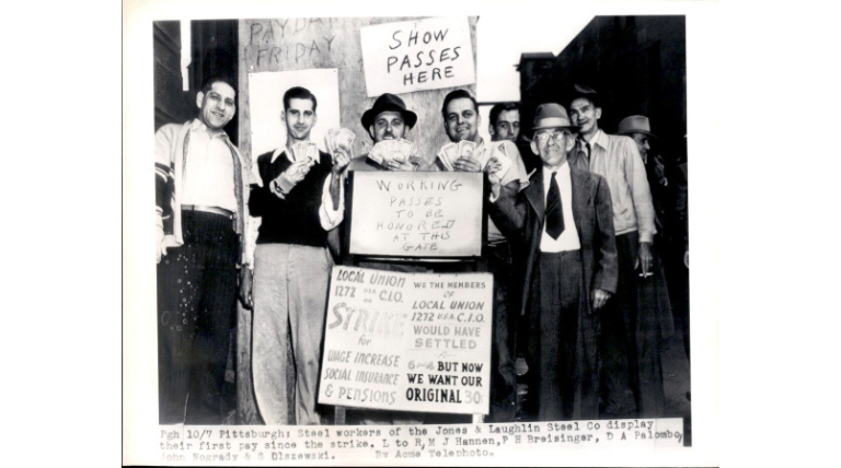 five men holding money in front of sign 