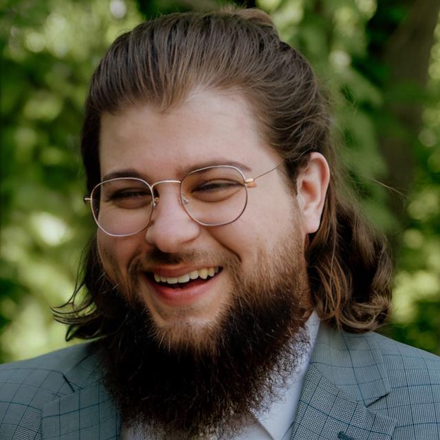 smiling person with glasses and beard outdoors