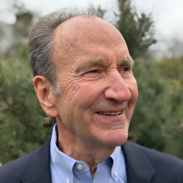Edward Kocher poses for a headshot against a gray background.