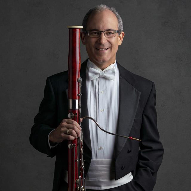 Philip Pandolfi wears a tuxedo and holds a bassoon.