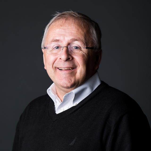 Shawn Funk wears a black sweater in front of a gray background.