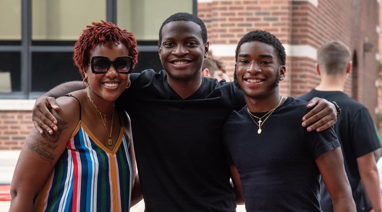 three people standing smiling