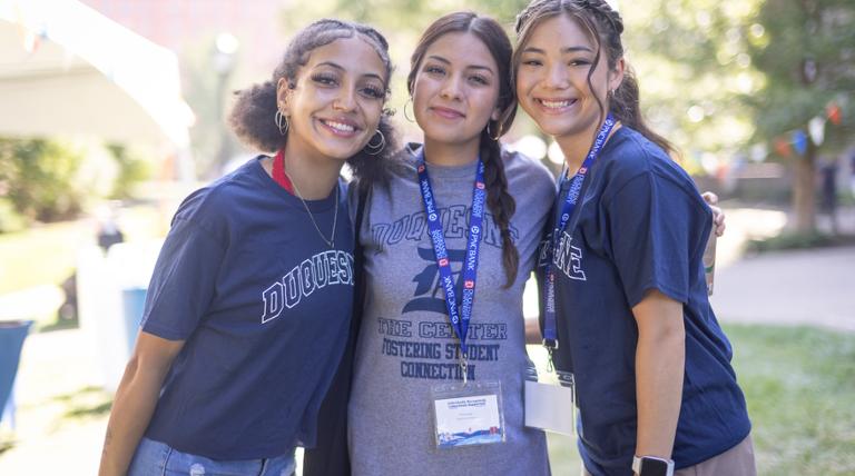 three girls standing smiling