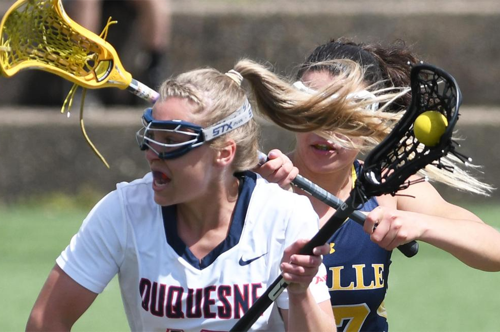 Two student athletes competing in women's lacrosse.