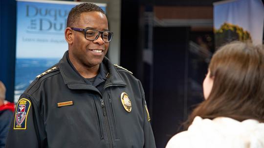 Chief Holmes smiles as he talks with a student on campus.