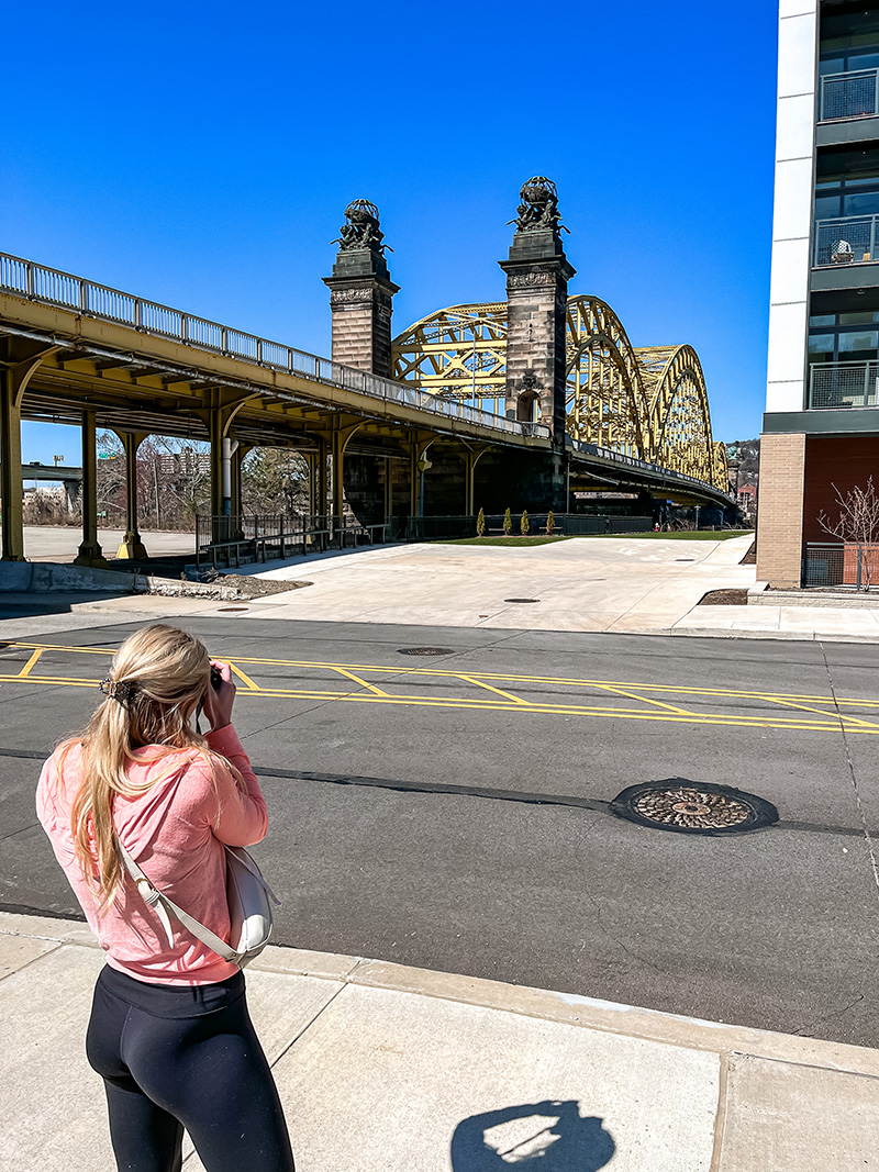 Emily Brozeski photographing a bridge in downtown Pittsburgh