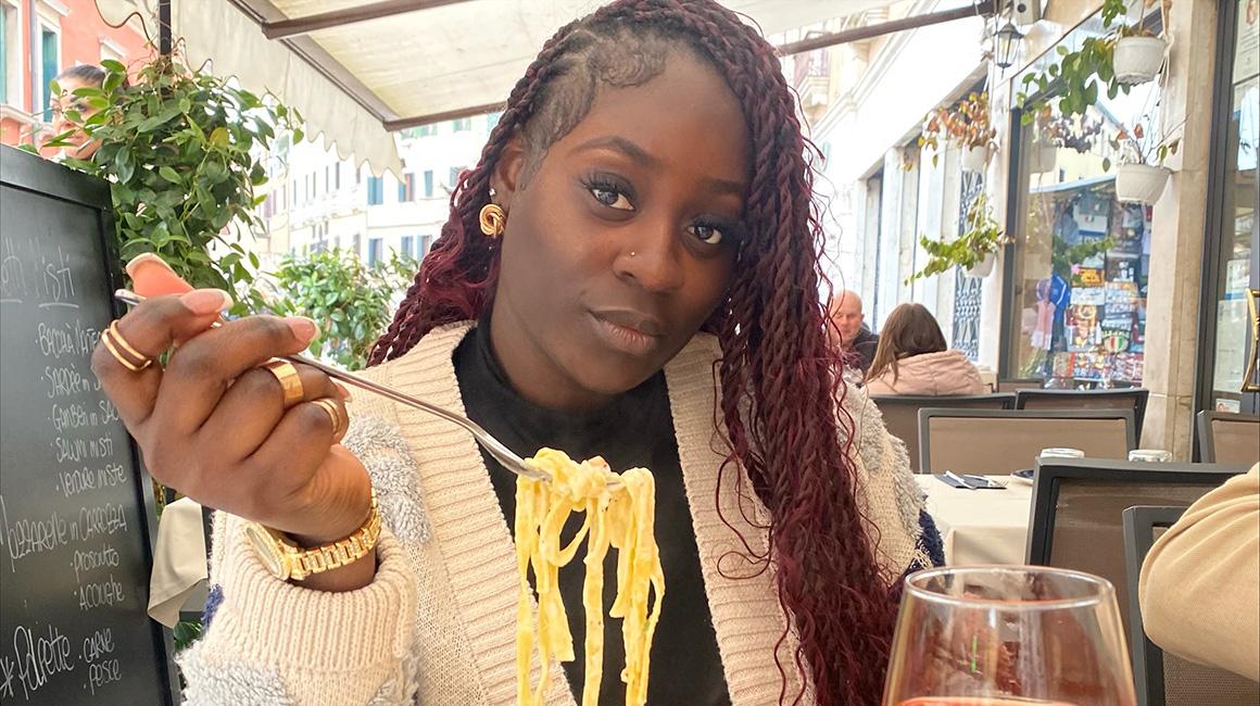 Jani Pierre at a restaurant in Italy eating pasta